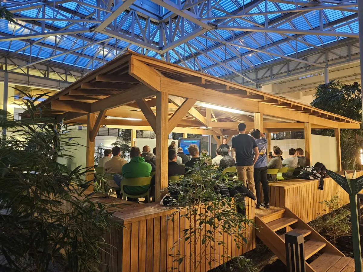 Le public du premier MUG Lille dans l'amphithéâtre en bois du campus Adeo, sous la verrière